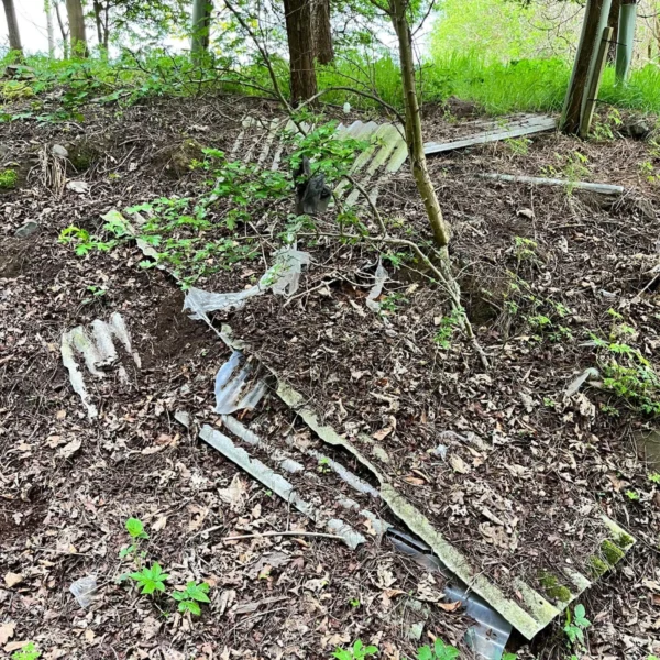 An assortment of construction debris and waste piled up in the English countryside.