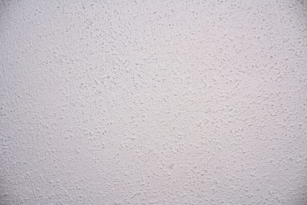 A white stipple patterned ceiling, also know as 'popcorn ceiling' finished with an Artex coating. 