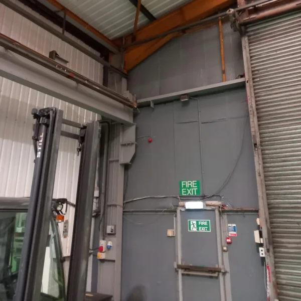An industrial warehouse with grey walls and a corrugated roof.