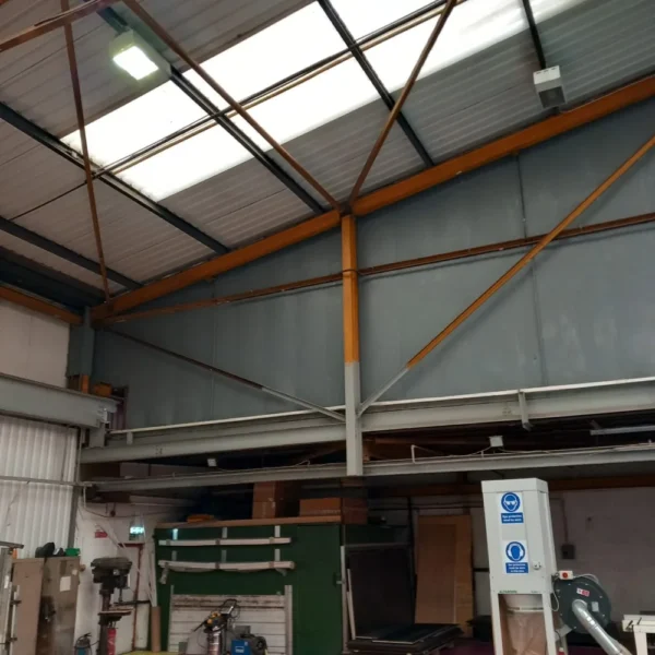 An industrial warehouse with grey walls and a corrugated roof.