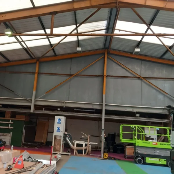 An industrial warehouse with grey walls and a corrugated roof.
