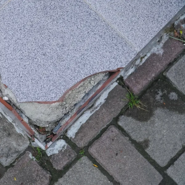 A broken tile next to paving stones.