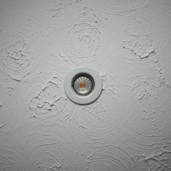 A light fitting on an Artex ceiling.